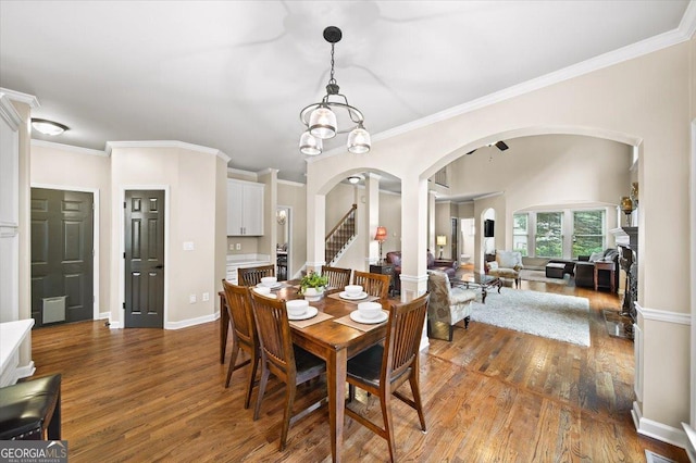 161 Highgrove Dr, Suwanee, GA 30024 - dining area with arched walkways, wood finished floors, ornamental molding, baseboards, and stairway