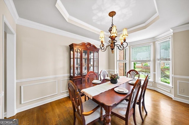 161 Highgrove Dr, Suwanee, GA 30024 - dining area featuring a chandelier, wood finished floors, a raised ceiling, ornamental molding, and a wainscoted wall