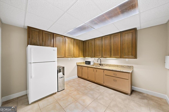 161 Highgrove Dr, Suwanee, GA 30024 - kitchen featuring white appliances, a drop ceiling, baseboards, a sink, and light tile patterned floors