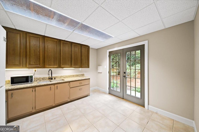 161 Highgrove Dr, Suwanee, GA 30024 - kitchen with french doors, a sink, a drop ceiling, baseboards, and light stone counters