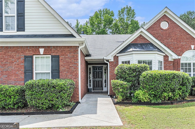 1108 The By Way, Mcdonough, GA 30252 - view of exterior entry featuring brick siding, a shingled roof, and a yard