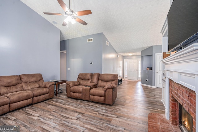 1108 The By Way, Mcdonough, GA 30252 - living room featuring a fireplace, a ceiling fan, a textured ceiling, wood finished floors, and high vaulted ceiling