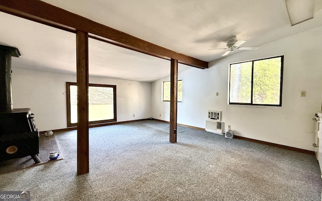 215 Audubon Ln, Clarkesville, GA 30523 - unfurnished living room featuring a wood stove, a ceiling fan, carpet floors, beam ceiling, and baseboards
