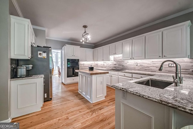 1325 Starboard Way, Cumming, GA 30041 - kitchen with a sink, white cabinets, tasteful backsplash, light stone counters, and crown molding