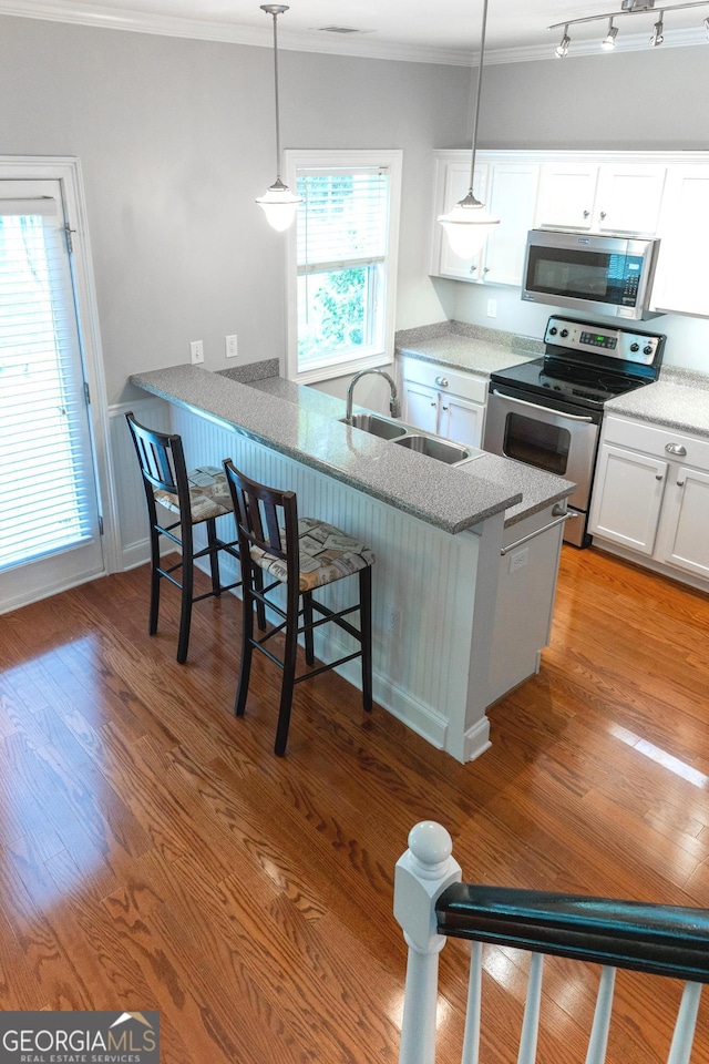 515 Edgewood Dr, Athens, GA 30606 - kitchen with stainless steel appliances, a sink, ornamental molding, white cabinets, and a peninsula