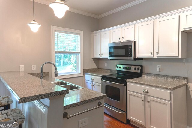 515 Edgewood Dr, Athens, GA 30606 - kitchen with appliances with stainless steel finishes, a peninsula, a sink, white cabinetry, and a kitchen breakfast bar
