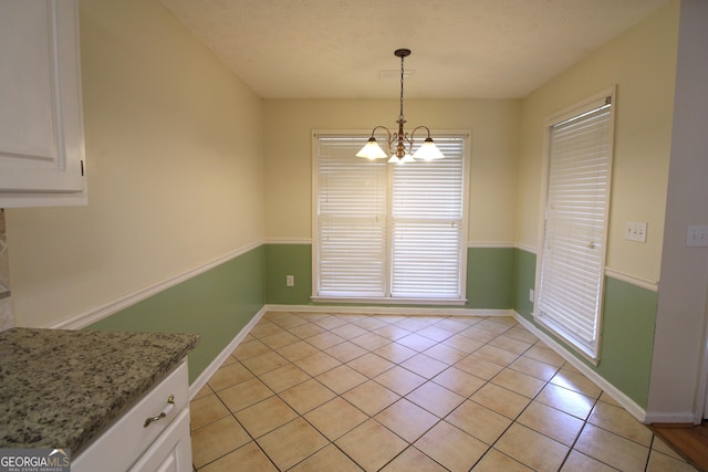 7976 Big Creek Pl, Columbus, GA 31904 - unfurnished dining area with a chandelier, light tile patterned floors, and baseboards