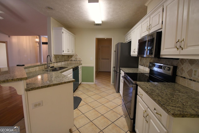 7976 Big Creek Pl, Columbus, GA 31904 - kitchen featuring stainless steel appliances, a breakfast bar area, a peninsula, tasteful backsplash, and white cabinets