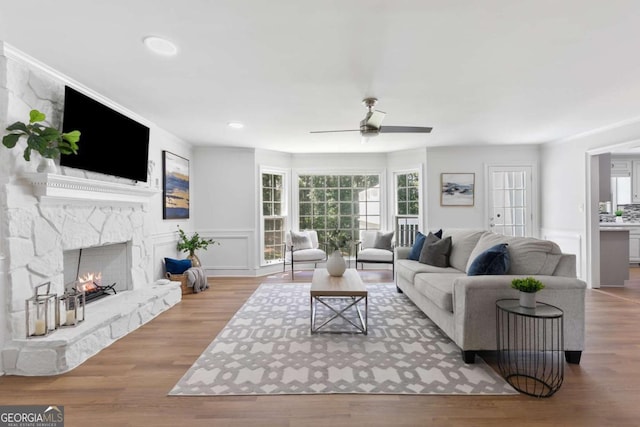 5706 Brookstone Walk NW, Acworth, GA 30101 - living room with a ceiling fan, wainscoting, recessed lighting, wood finished floors, and a lit fireplace