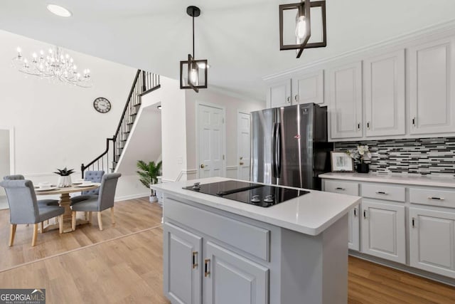 5706 Brookstone Walk NW, Acworth, GA 30101 - kitchen featuring freestanding refrigerator, a chandelier, light wood-style flooring, a center island, and black electric stovetop