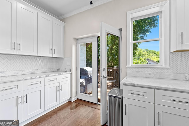73 Fair St, Newnan, GA 30263 - kitchen featuring dark wood-style floors, crown molding, plenty of natural light, white cabinetry, and tasteful backsplash