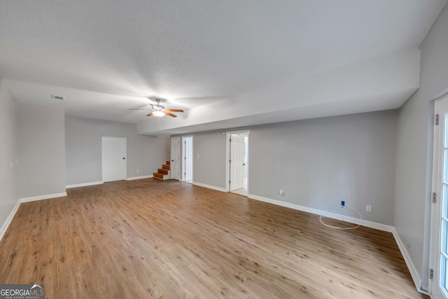 112 White Oak Cir, Dublin, GA 31021 - unfurnished living room featuring wood finished floors, stairway, baseboards, and a ceiling fan