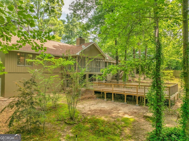 112 White Oak Cir, Dublin, GA 31021 - back of property with a chimney, a deck, and roof with shingles
