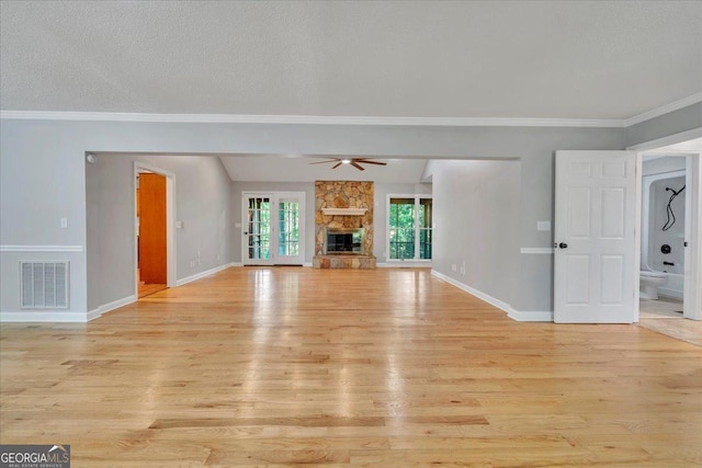 112 White Oak Cir, Dublin, GA 31021 - unfurnished living room featuring light wood-type flooring, ceiling fan, ornamental molding, baseboards, and a stone fireplace