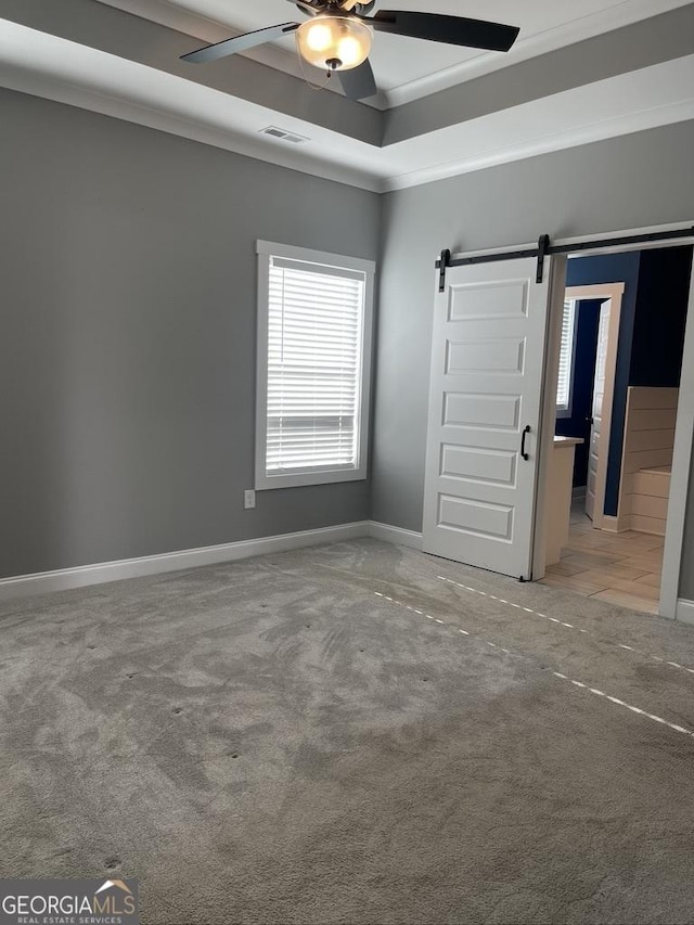 15785 Concord St, Zebulon, GA 30295 - unfurnished bedroom with a barn door, carpet, baseboards, a ceiling fan, and a raised ceiling