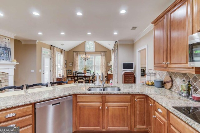 901 Providence Ln, Monroe, GA 30656 - kitchen with stainless steel appliances, a sink, light stone counters, a peninsula, and ornamental molding