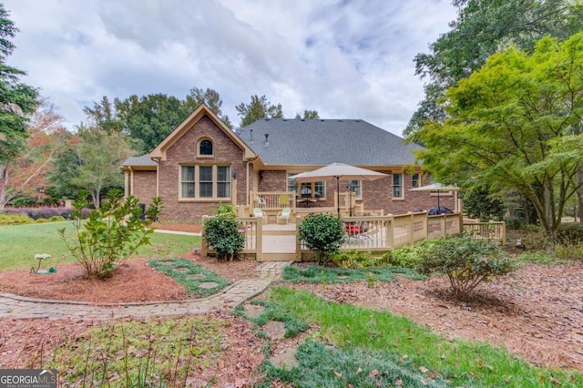 901 Providence Ln, Monroe, GA 30656 - back of house with brick siding, a wooden deck, roof with shingles, and a yard