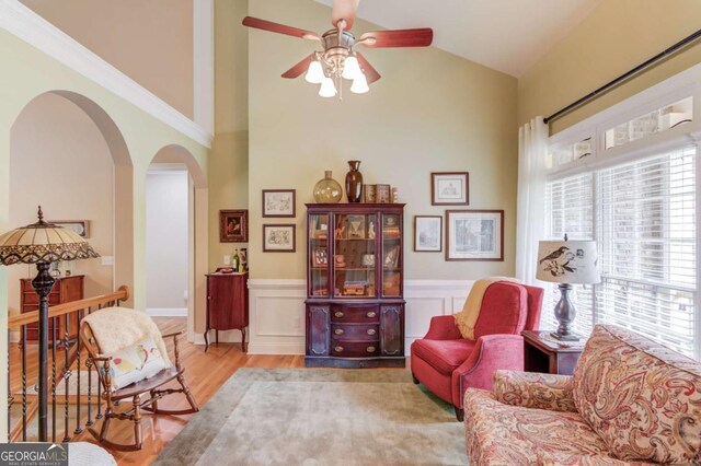 901 Providence Ln, Monroe, GA 30656 - living area with arched walkways, a ceiling fan, wood finished floors, a wainscoted wall, and high vaulted ceiling