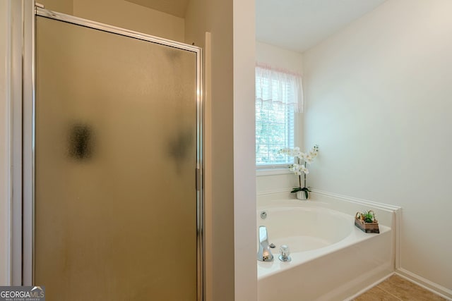 435 Flowering Trl, Grayson, GA 30017 - bathroom featuring a stall shower, a garden tub, tile patterned flooring, and baseboards