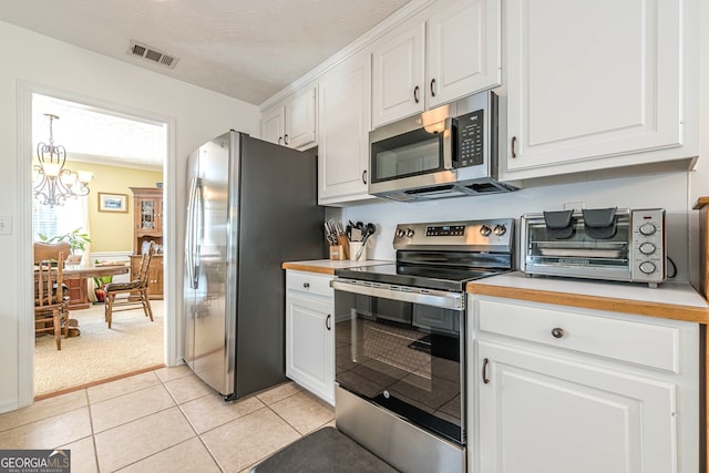 435 Flowering Trl, Grayson, GA 30017 - kitchen with appliances with stainless steel finishes, white cabinetry, light countertops, a chandelier, and light tile patterned flooring