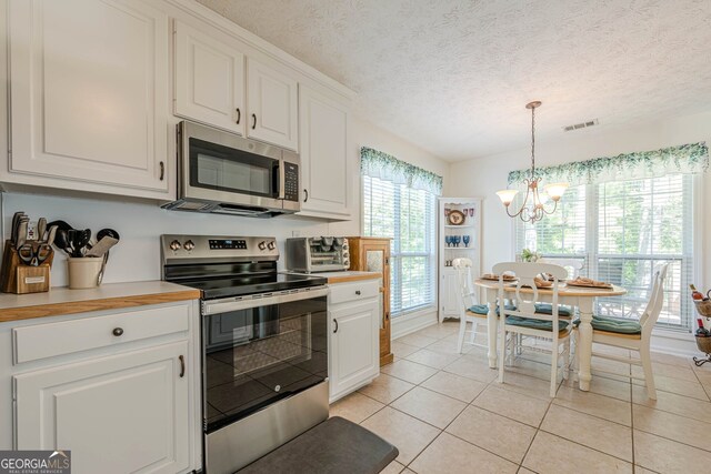 435 Flowering Trl, Grayson, GA 30017 - kitchen featuring stainless steel appliances, a chandelier, light tile patterned floors, white cabinetry, and a textured ceiling