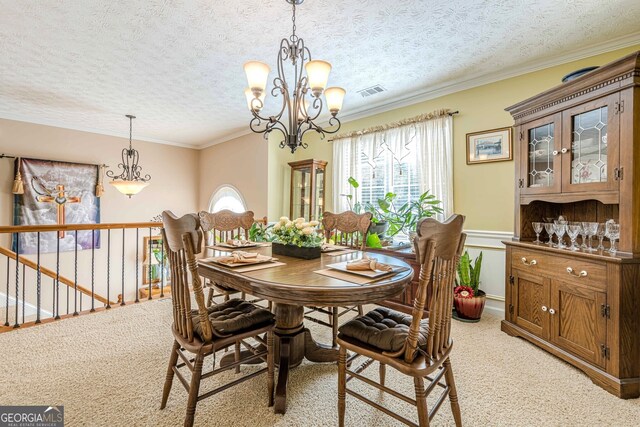 435 Flowering Trl, Grayson, GA 30017 - dining room with a chandelier, a textured ceiling, light colored carpet, crown molding, and wainscoting