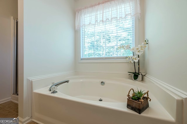 435 Flowering Trl, Grayson, GA 30017 - bathroom featuring a bath and a shower with door