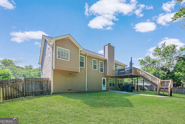 435 Flowering Trl, Grayson, GA 30017 - back of property with a chimney, stairway, a wooden deck, and a patio
