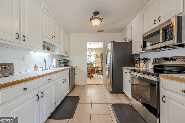 435 Flowering Trl, Grayson, GA 30017 - kitchen featuring stainless steel appliances, white cabinets, light countertops, a chandelier, and a sink