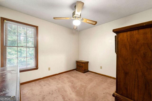 7281 Fernwood Dr, Riverdale, GA 30296 - unfurnished bedroom featuring light colored carpet, baseboards, and a ceiling fan