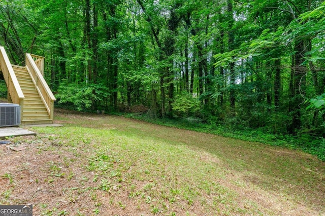 7281 Fernwood Dr, Riverdale, GA 30296 - view of yard featuring stairway, central AC, and a wooded view