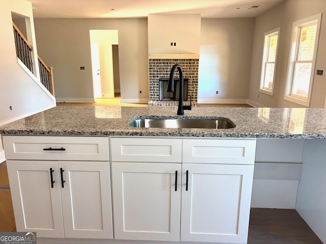 1705 Lake Dow Rd, Mcdonough, GA 30252 - kitchen with a sink, white cabinetry, and light stone counters