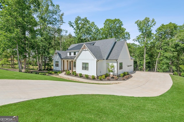 210 Birmingham Rd, Ball Ground, GA 30107 - modern farmhouse with curved driveway, a front yard, a garage, and board and batten siding