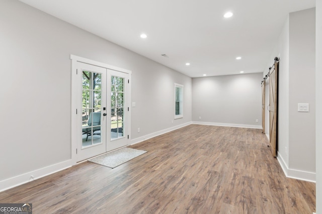 210 Birmingham Rd, Ball Ground, GA 30107 - unfurnished room featuring a barn door, french doors, wood finished floors, recessed lighting, and baseboards