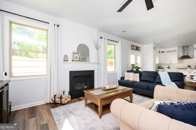 3537 Edenridge Ct, Buford, GA 30519 - living room featuring dark wood-type flooring, a ceiling fan, a large fireplace, and baseboards