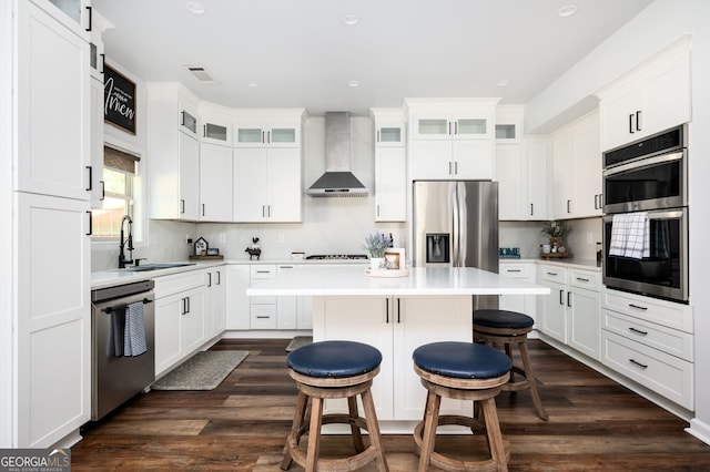 3537 Edenridge Ct, Buford, GA 30519 - kitchen featuring wall chimney exhaust hood, appliances with stainless steel finishes, a sink, a kitchen island, and a kitchen bar