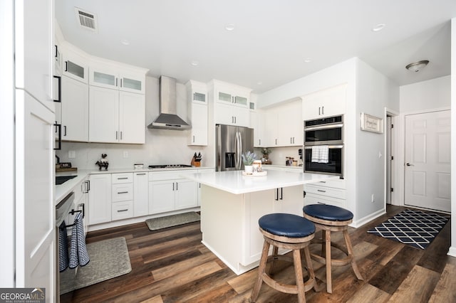 3537 Edenridge Ct, Buford, GA 30519 - kitchen with stainless steel appliances, wall chimney exhaust hood, dark wood-style flooring, a kitchen island, and a kitchen breakfast bar
