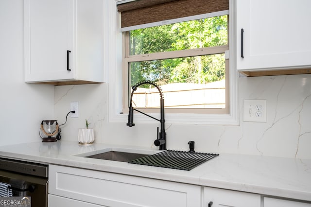 3537 Edenridge Ct, Buford, GA 30519 - kitchen with stainless steel dishwasher, a sink, white cabinetry, and light stone countertops