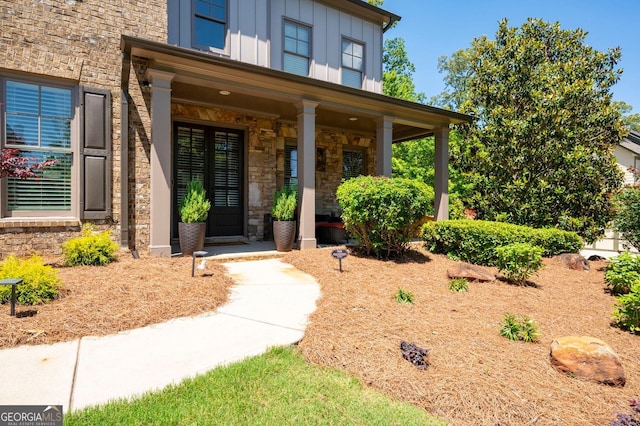 2470 Anderson Estates Ct, Marietta, GA 30064 - view of exterior entry with board and batten siding, stone siding, and covered porch