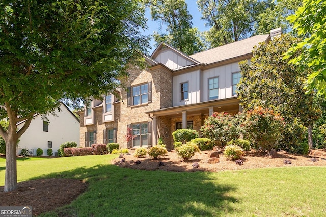 2470 Anderson Estates Ct, Marietta, GA 30064 - view of front of house with board and batten siding, a front yard, stone siding, and a chimney