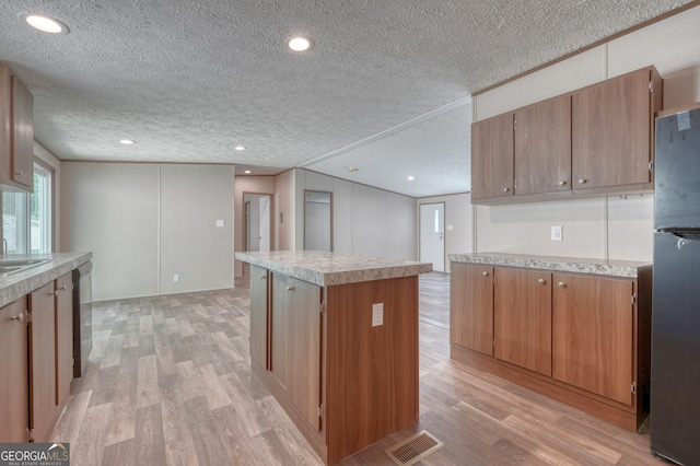 64 Town View Cir, Blairsville, GA 30512 - kitchen with a textured ceiling, light wood finished floors, light countertops, a center island, and freestanding refrigerator