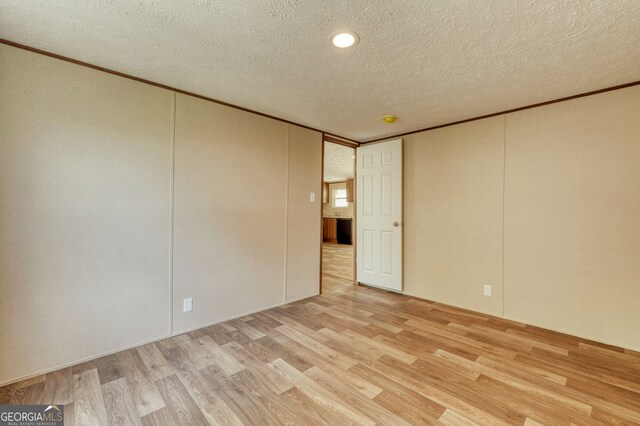 64 Town View Cir, Blairsville, GA 30512 - unfurnished room featuring light wood finished floors, ornamental molding, and a textured ceiling