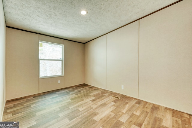 64 Town View Cir, Blairsville, GA 30512 - empty room featuring light wood finished floors, a textured ceiling, and crown molding