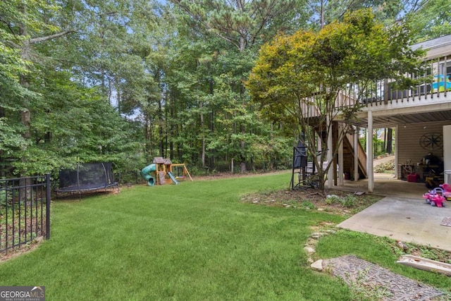 25 Grange Ct, Sharpsburg, GA 30277 - view of grassy yard with a trampoline, a patio, a playground, a wooden deck, and stairs
