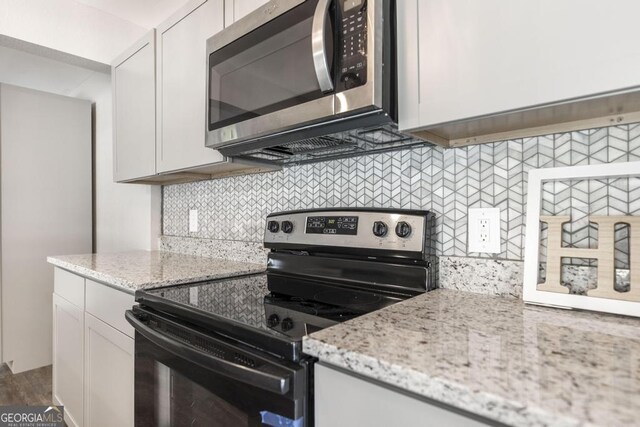 108 Holly St, Warner Robins, GA 31093 - kitchen with appliances with stainless steel finishes, tasteful backsplash, white cabinets, and light stone countertops