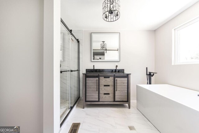 108 Holly St, Warner Robins, GA 31093 - bathroom with marble look tiles, a soaking tub, a shower stall, double vanity, and a chandelier