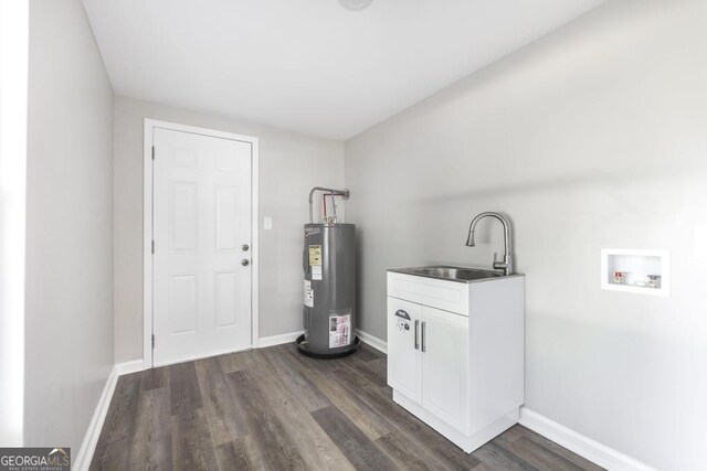 108 Holly St, Warner Robins, GA 31093 - washroom featuring electric water heater, a sink, hookup for a washing machine, dark wood-style flooring, and baseboards