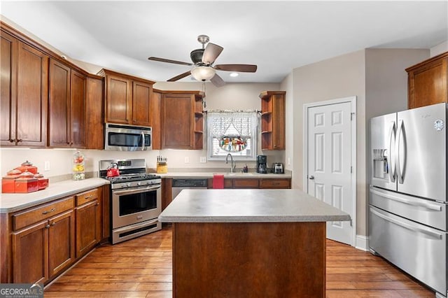 1070 Cureton Dr, Austell, GA 30106 - kitchen featuring appliances with stainless steel finishes, open shelves, ceiling fan, a center island, and light wood finished floors