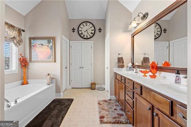 1070 Cureton Dr, Austell, GA 30106 - full bath with double vanity, a garden tub, lofted ceiling, tile patterned floors, and a closet