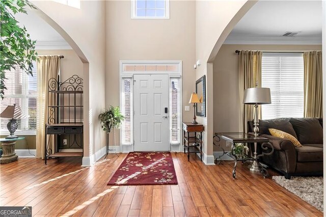 1070 Cureton Dr, Austell, GA 30106 - entryway with arched walkways, crown molding, plenty of natural light, hardwood / wood-style flooring, and a high ceiling